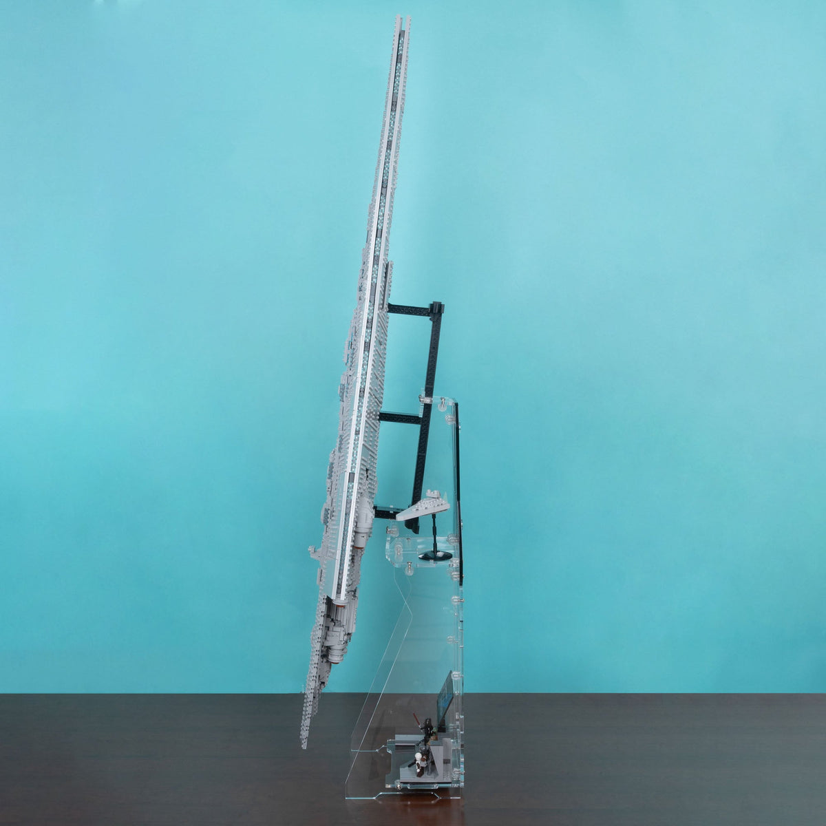 A detailed star wars lego 75457 model on a clear acrylic stand with support arms, set against a solid turquoise background.