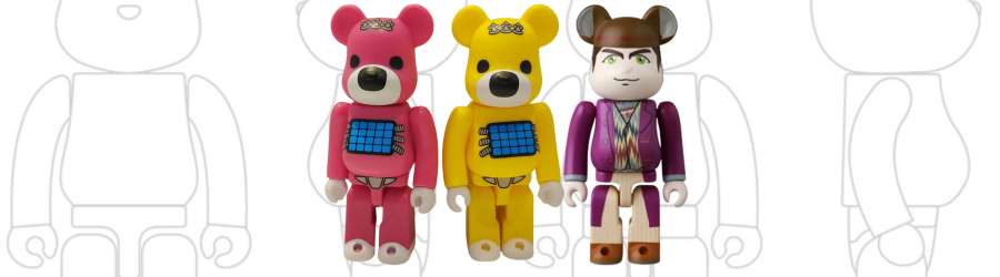 three bearbrick figures, one pink one yellow, one willy wonka